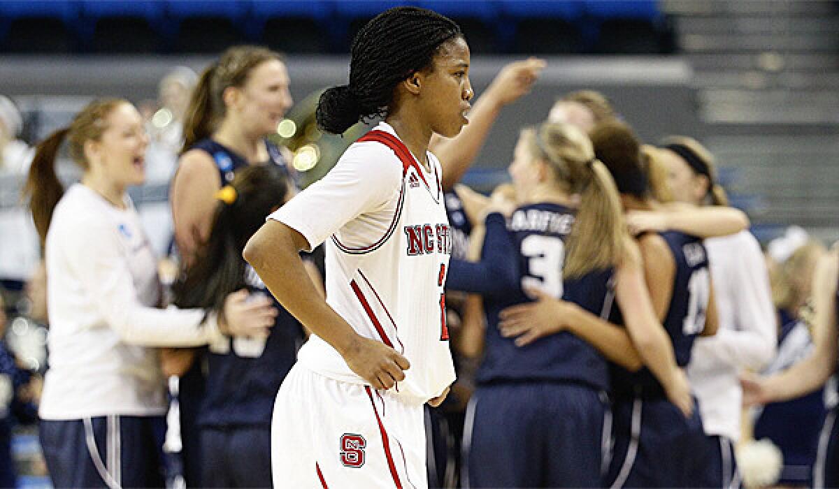 North Carolina State's Len'Nique Brown walks off the court as BYU players celebrate their 72-57 win Saturday in Los Angeles.