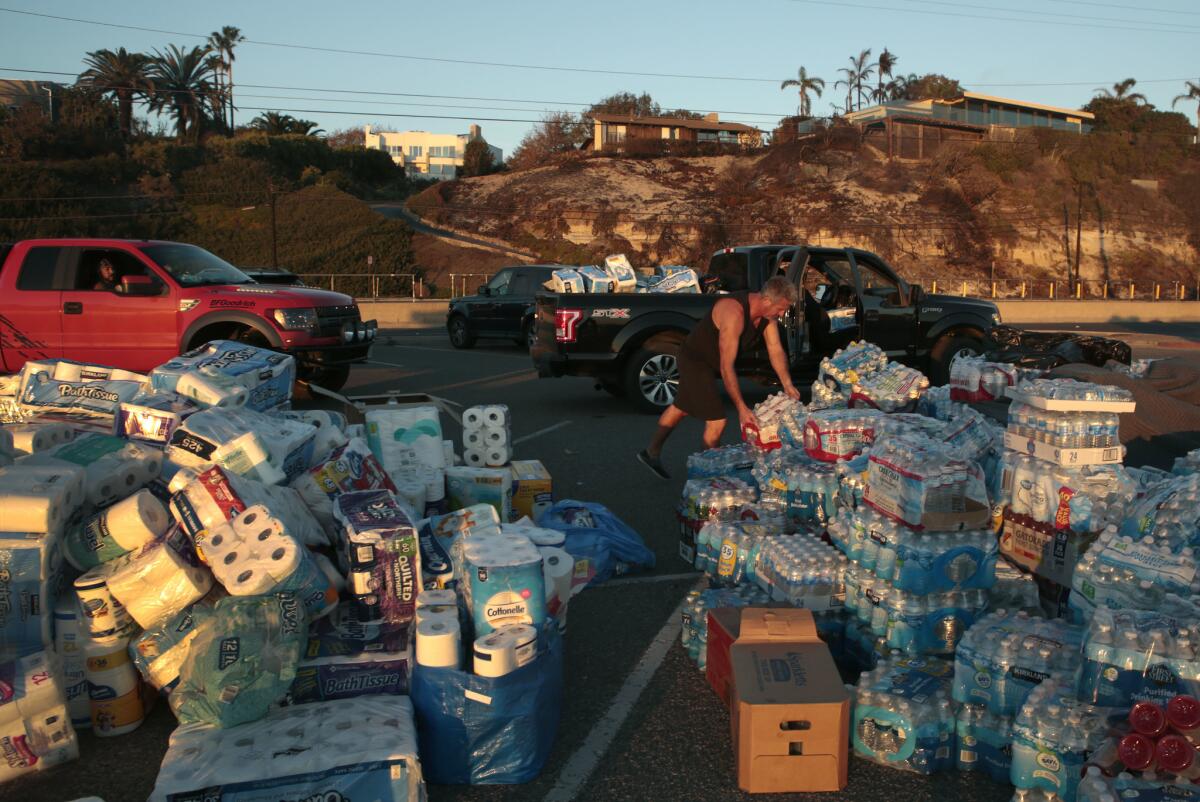 Malibu residents collect supplies at another relief center set up Wednesday in the Zuma Beach parking lot in Malibu