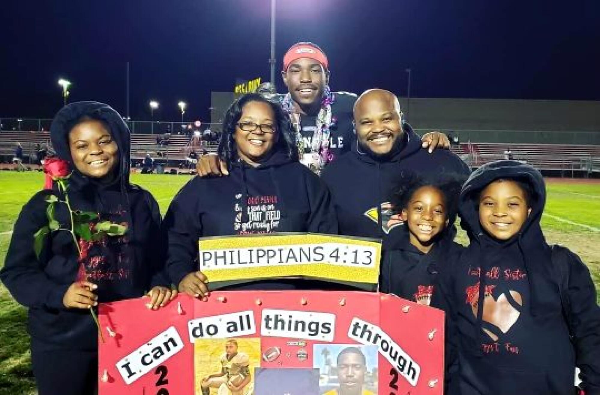 Jalon Daniels, center, is joined his family during his high school football senior day. 