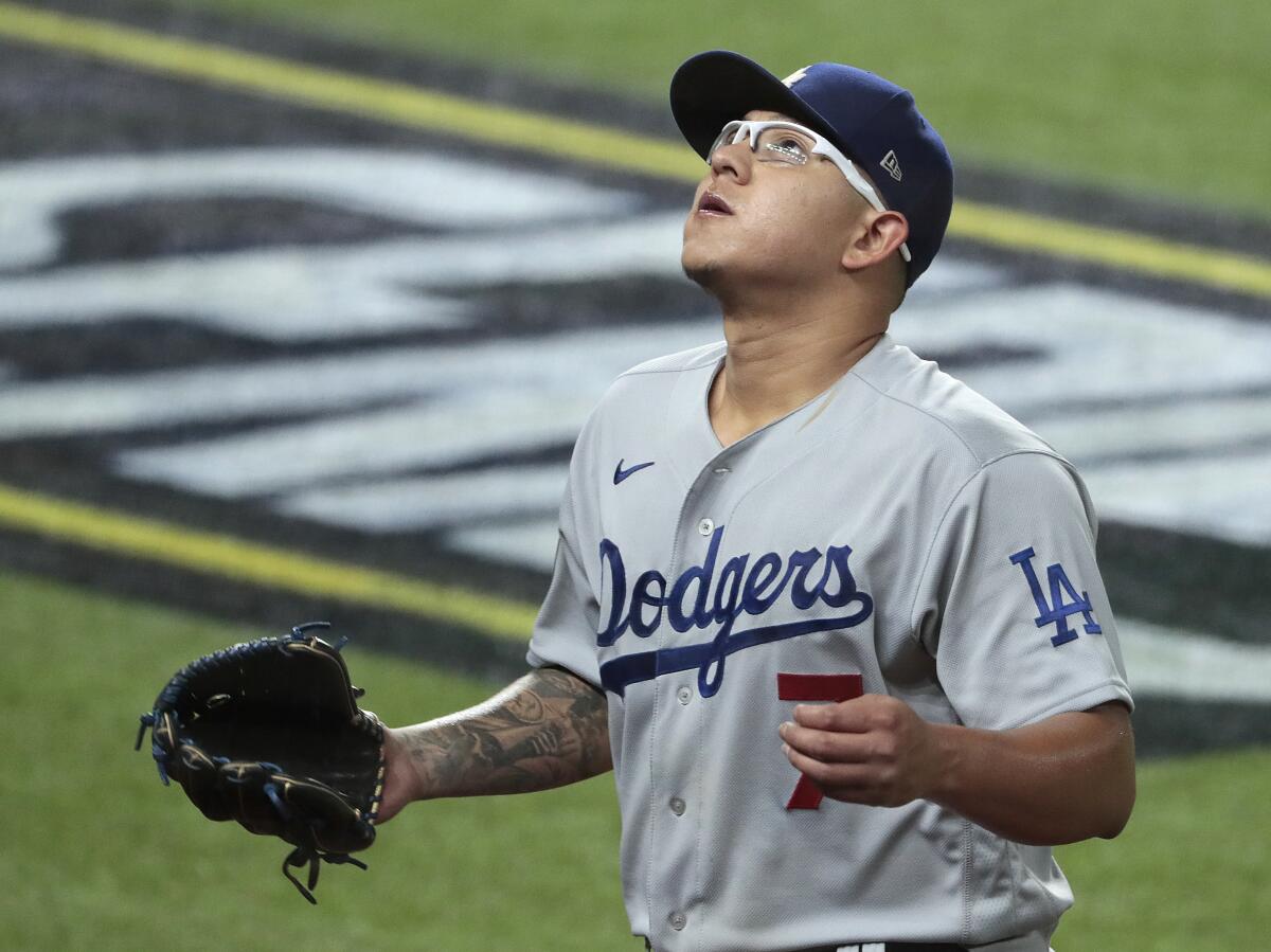 On the field, Dodgers pitcher Julio Urías looks up.