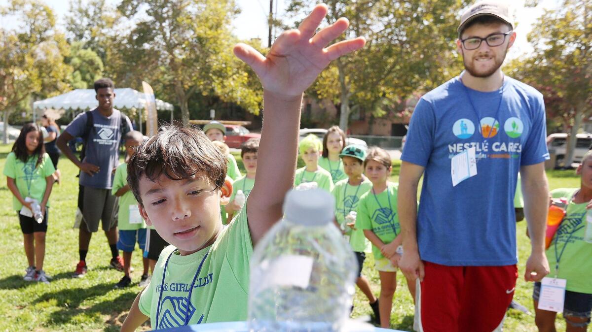 Jacob Hernandez, 8, of Sun Valley, drops a bottle into a recycling bin at Robert E. Lundigan Park where Nestlé and the Boys & Girls Club of Burbank and Greater East Valley worked together to teach young children about conservation on Aug. 10.