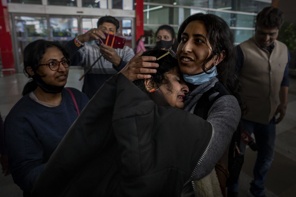 Mansi Singhal, an Indian student studying in Ukraine who fled the conflict, hugs her mother after she arrived at Indira Gandhi International Airport in New Delhi, India, Wednesday, March 2, 2022. (AP Photo/Altaf Qadri)