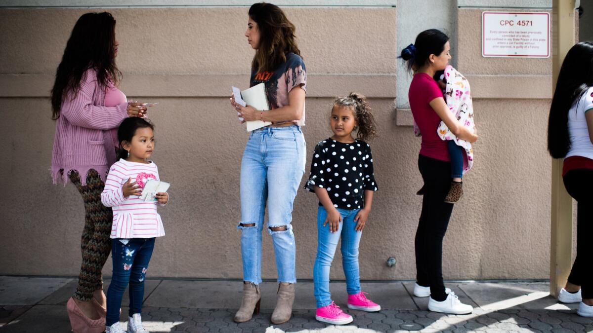 Natalie Garcia, center, and her daughter Marley wait to visit Garcia's father in detention.