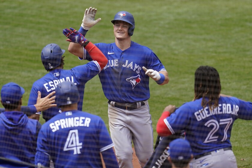 Toronto Blue Jays' Matt Chapman, top, is congratulated by teammates after hitting a home run against the Oakland Athletics during the seventh inning of a baseball game in Oakland, Calif., Wednesday, July 6, 2022. (AP Photo/Jeff Chiu)