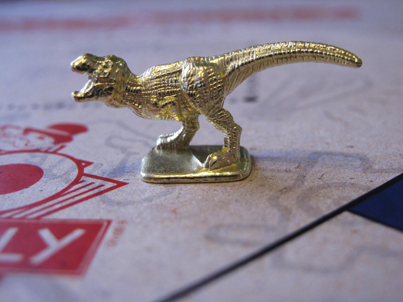 This March 15, 2017 photo shows the T-Rex dinosaur, one of three new tokens that will be included in upcoming versions of the board game Monopoly, in Atlantic City, N.J. Hasbro Inc. revealed the results of voting on Friday, March 17, 2017. Leaving the game will be the boot, wheelbarrow and thimble tokens.