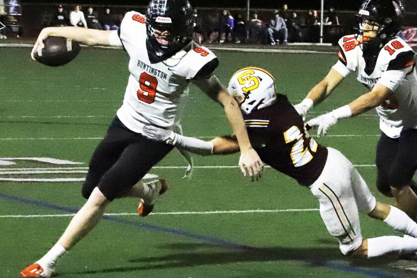 Huntington Beach's quarterback Brady Edmunds (9) runs for the first down during Huntington Beach High School boys' football team against Simi Valley High School boys' football team in the semifinals of the CIF Southern Section Division 6 playoff game at Simi Valley High School in Simi Valley on Friday, November 17, 2023. (Photo by James Carbone)