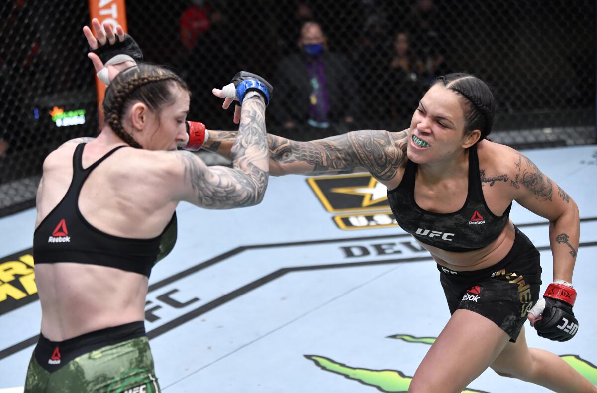 LAS VEGAS, NEVADA - MARCH 06: (R-L) Amanda Nunes of Brazil punches Megan Anderson of Australia.