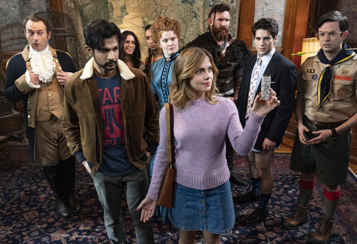 This image released by CBS shows Utkarsh Ambudkar, foreground left, and Rose McIver in a scene from the comedy series "Ghosts." (Cliff Lipson/CBS via AP)
