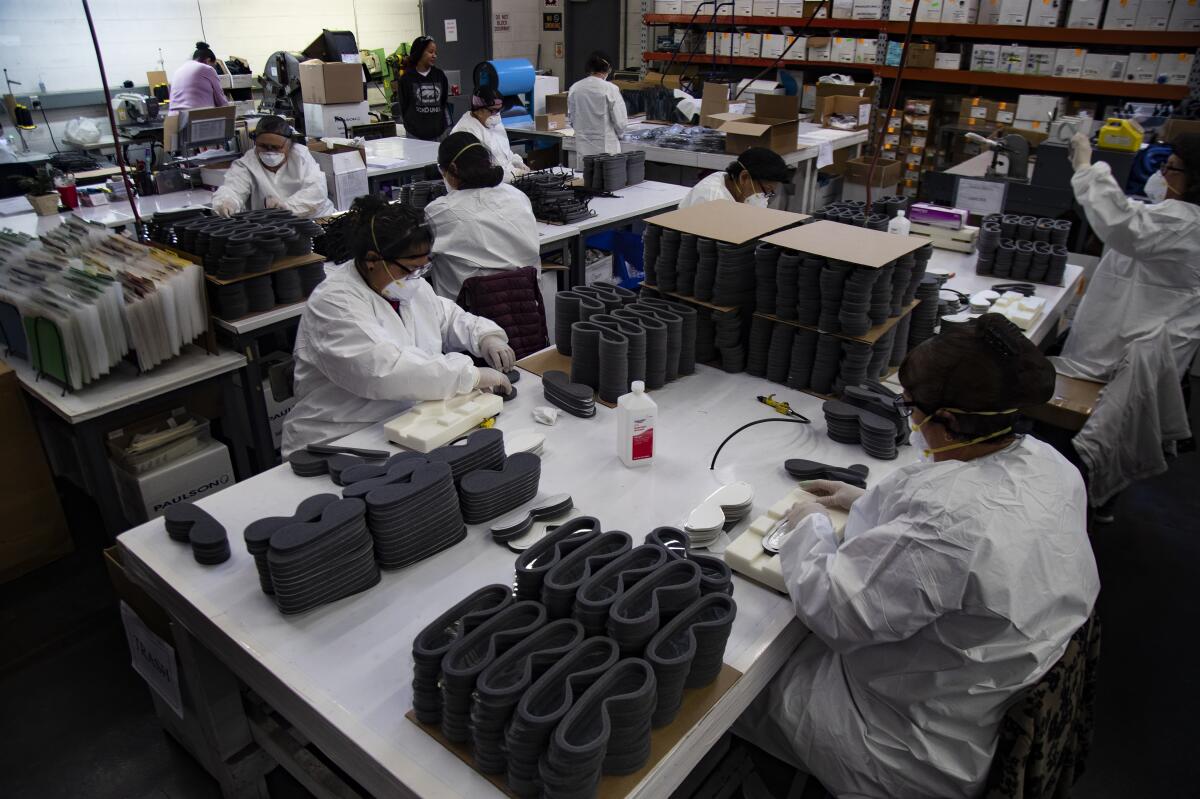 Workers at Paulson Manufacturing in Temecula, Calif., assemble medical goggles for shipment to China to help prevent the spread of the coronavirus.