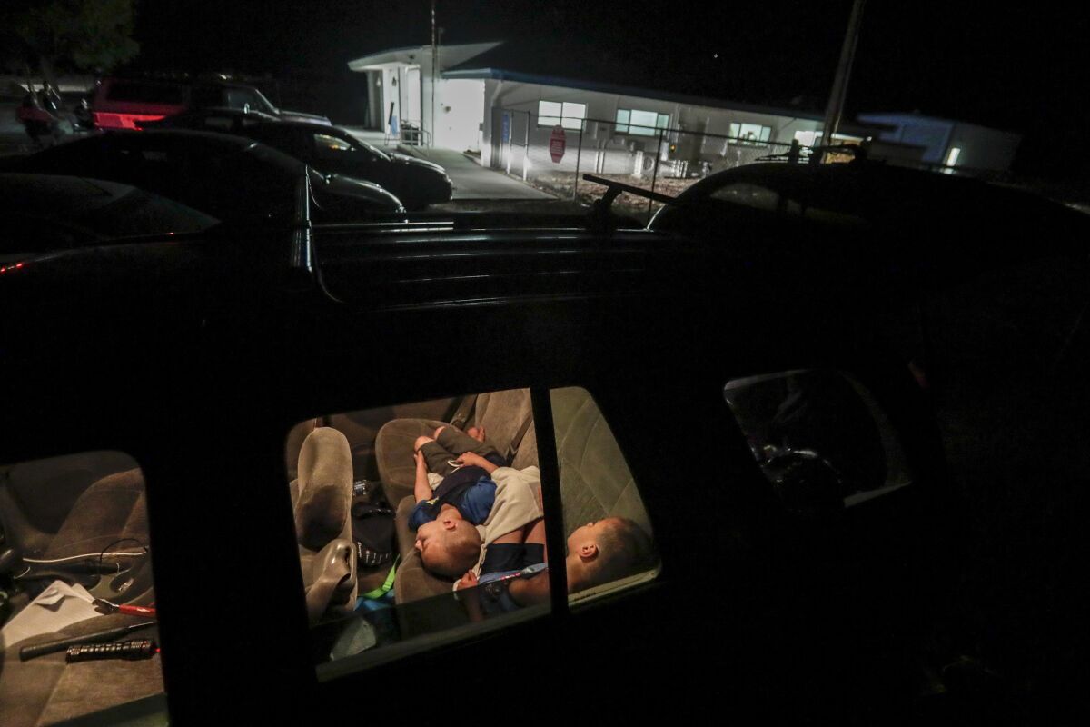 Brothers Joey, 8, right, and Jimmy Raya, 5, sleep in the back seat of their mother’s car in the parking lot of San Bernardino County Fire Station 57 in Trona after their home was damaged in a 7.1 magnitude earthquake hours earlier. (Robert Gauthier / Los Angeles Times)