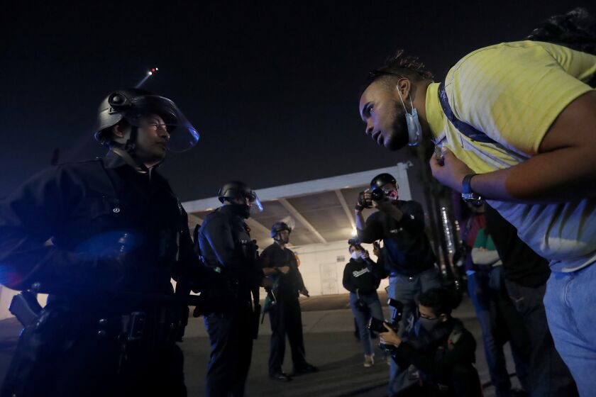 LOS ANGELES, CA - NOV. 3, 2020. A protester berates a police officer in downtown Los Angeles on election night, Tuesday, Nov. 3, 2020. (Luis Sinco / Los Angeles Times)