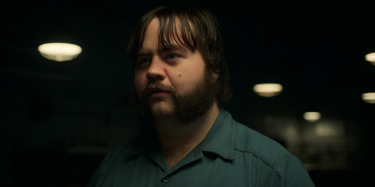 A bearded, brown-haired man in a prison jumpsuit in a scene from "Black Bird."