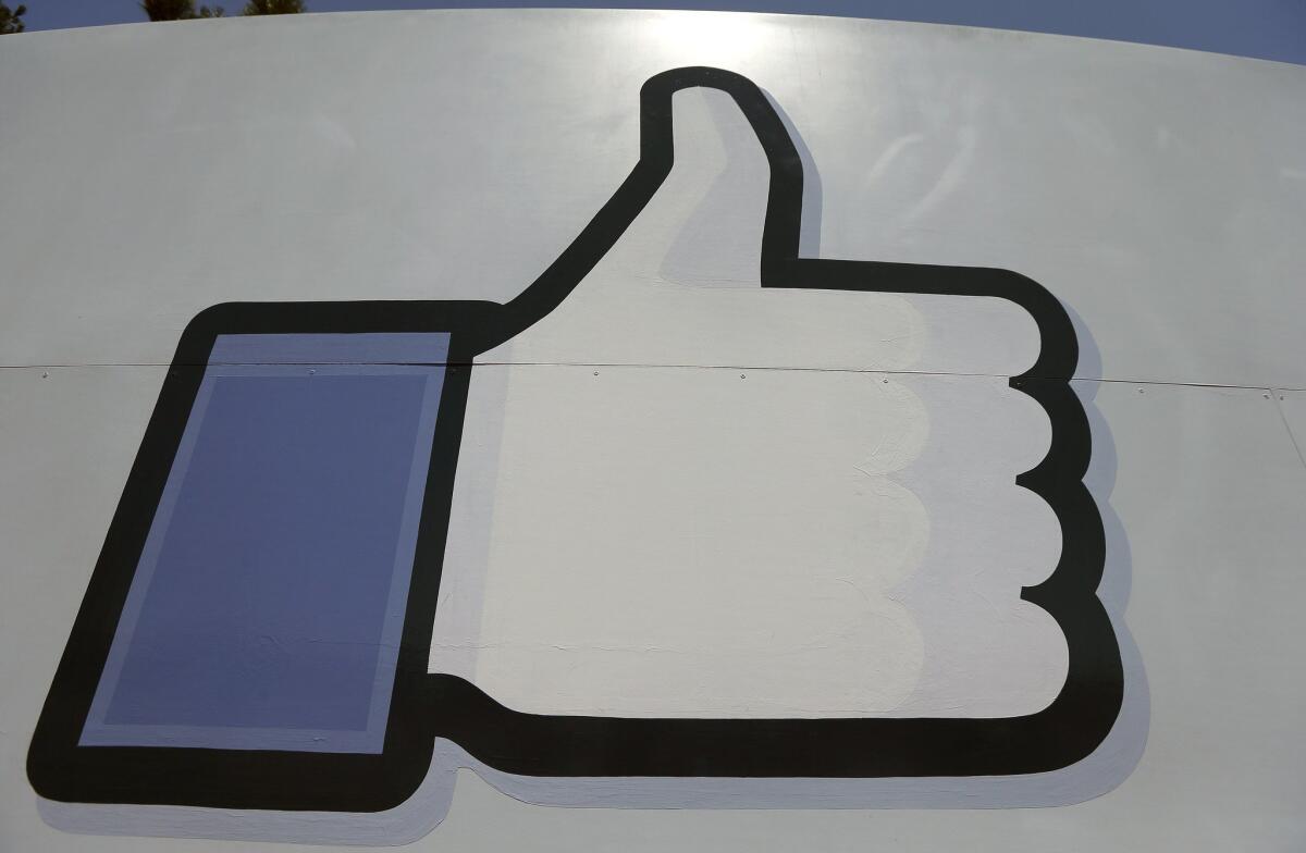 Facebook's "like" symbol sits at the entrance to the company's campus in Menlo Park, Calif. The company said Tuesday that it is working on a type of "dislike" button.