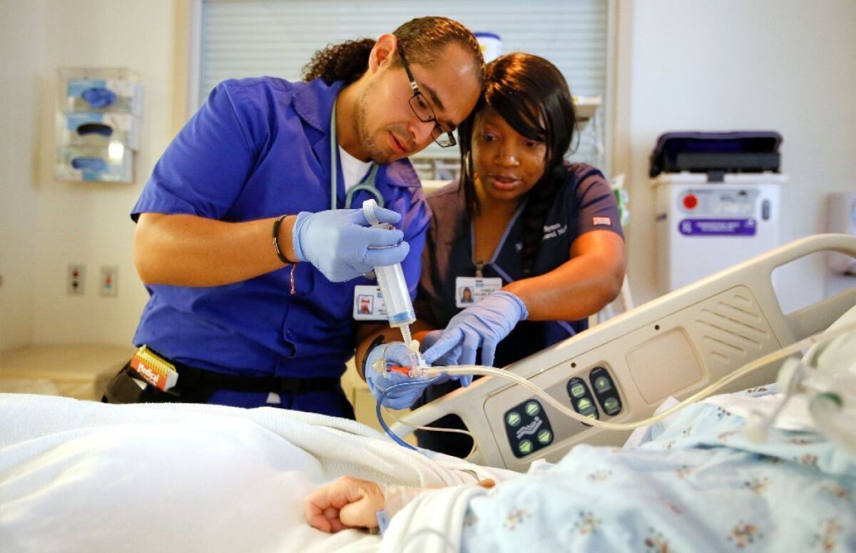 Nurses attend to a patient at UCLA Medical Center in Santa Monica. A new study finds that registered nurses who are men earn more than their counterparts who are women.