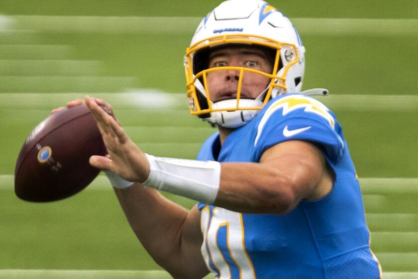 INGLEWOOD, CA - OCTOBER 25: Chargers quarterback Justin Herbert, looks for a receiver against the Jaguars in the first half at an empty SoFi Stadium on Sunday, Oct. 25, 2020 in Inglewood, CA. The rookie finished 27 of 43 for 347 yards and three touchdowns. He also led the Chargers in rushing with 66 yards on nine carries and scored a touchdown on the ground. Herbert's 66 yards set a franchise record for rushing yards by a quarterback. (Allen J. Schaben / Los Angeles Times)