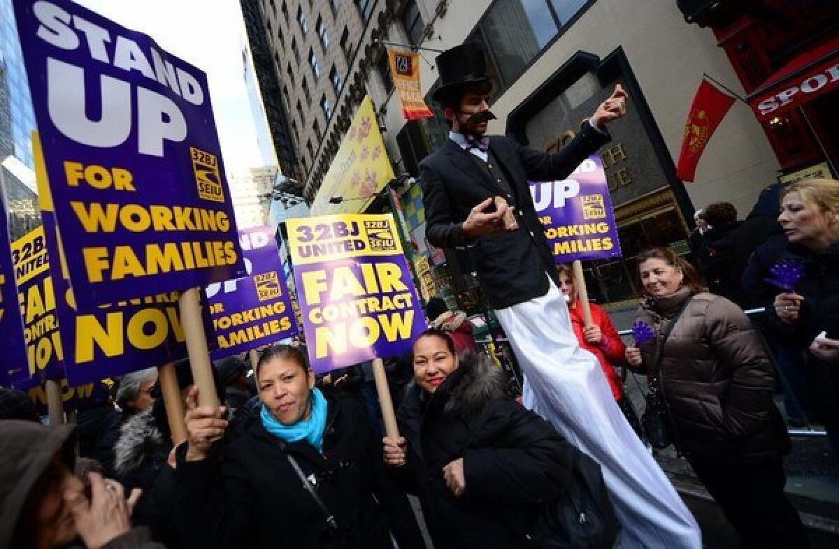 Protesters show their support for Broadway theater cleaners, porters and matrons at a demonstration in Times Square in New York. The union representing Broadway service workers is threatening a strike over healthcare benefits.