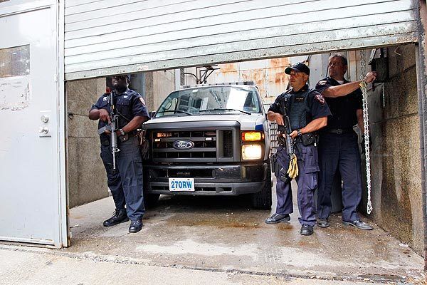 Heavily armed corrections officers stand guard as a Department of Corrections vehicle arrives at Manhattan Criminal Court in the case of Dominique Strauss-Kahn.