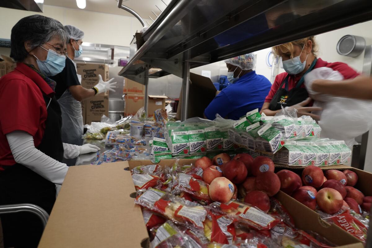 LAUSD food service workers pre-package hundreds of free school lunches in plastic bags