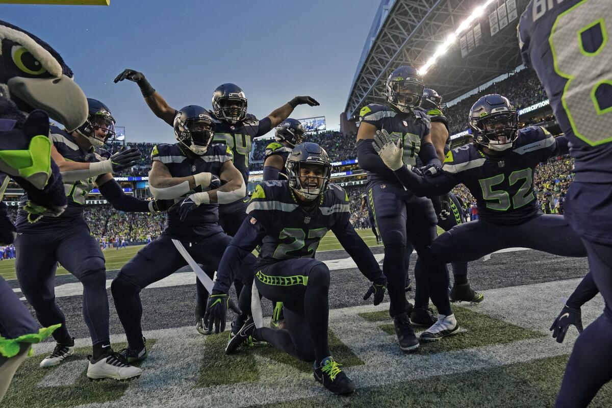 Seahawks players celebrate after an interception by safety Quandre Diggs in overtime against the Rams on Sunday.