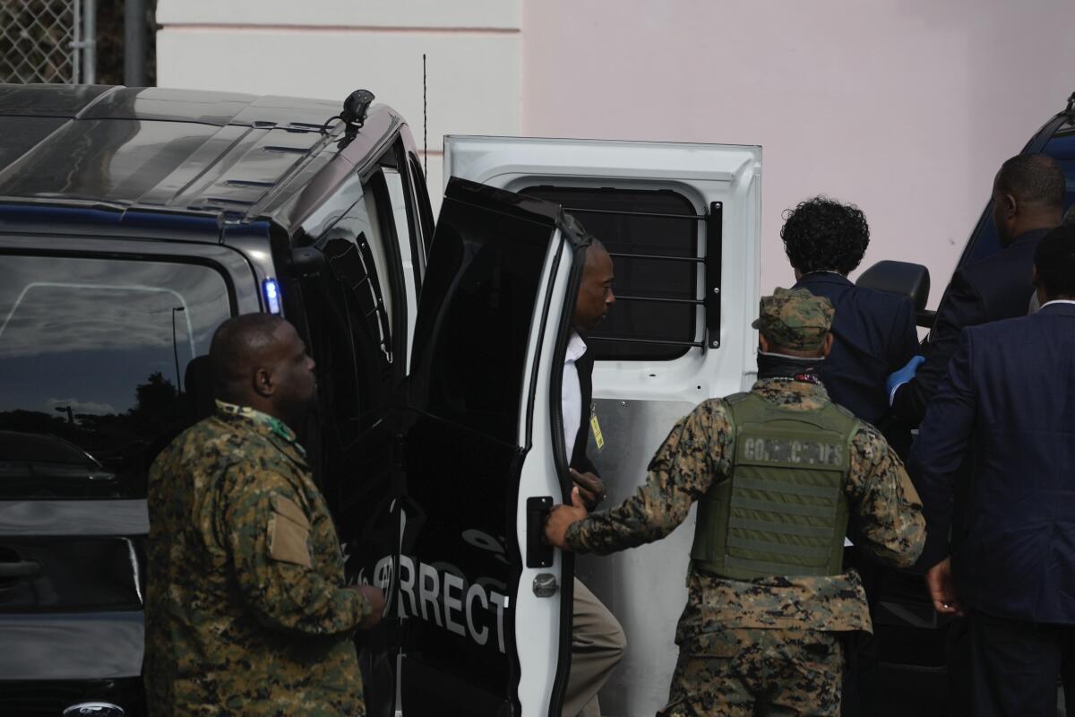 FTX founder Sam Bankman-Fried, top right, is escorted from a corrections van to court in Nassau, Bahamas