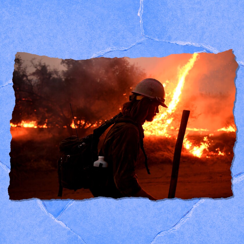 A firefighter silhouetted against a fire.