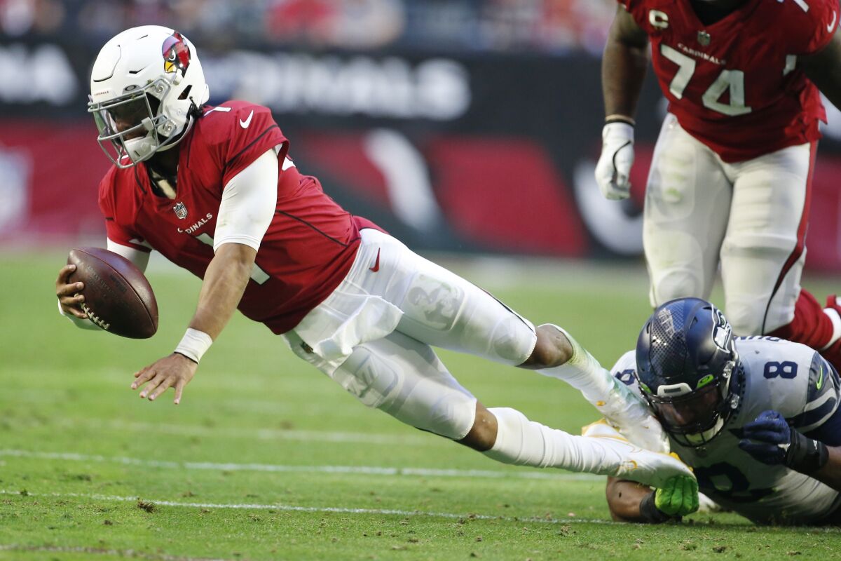 Arizona Cardinals quarterback Kyler Murray (1) is sacked by Seattle Seahawks defensive end Carlos Dunlap (8) during the first half of an NFL football game Sunday, Jan. 9, 2022, in Glendale, Ariz. (AP Photo/Ralph Freso)