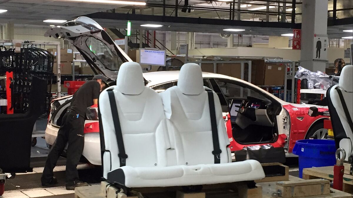 Seats are ready for installation at the Tesla assembly plant in Fremont, Calif.
