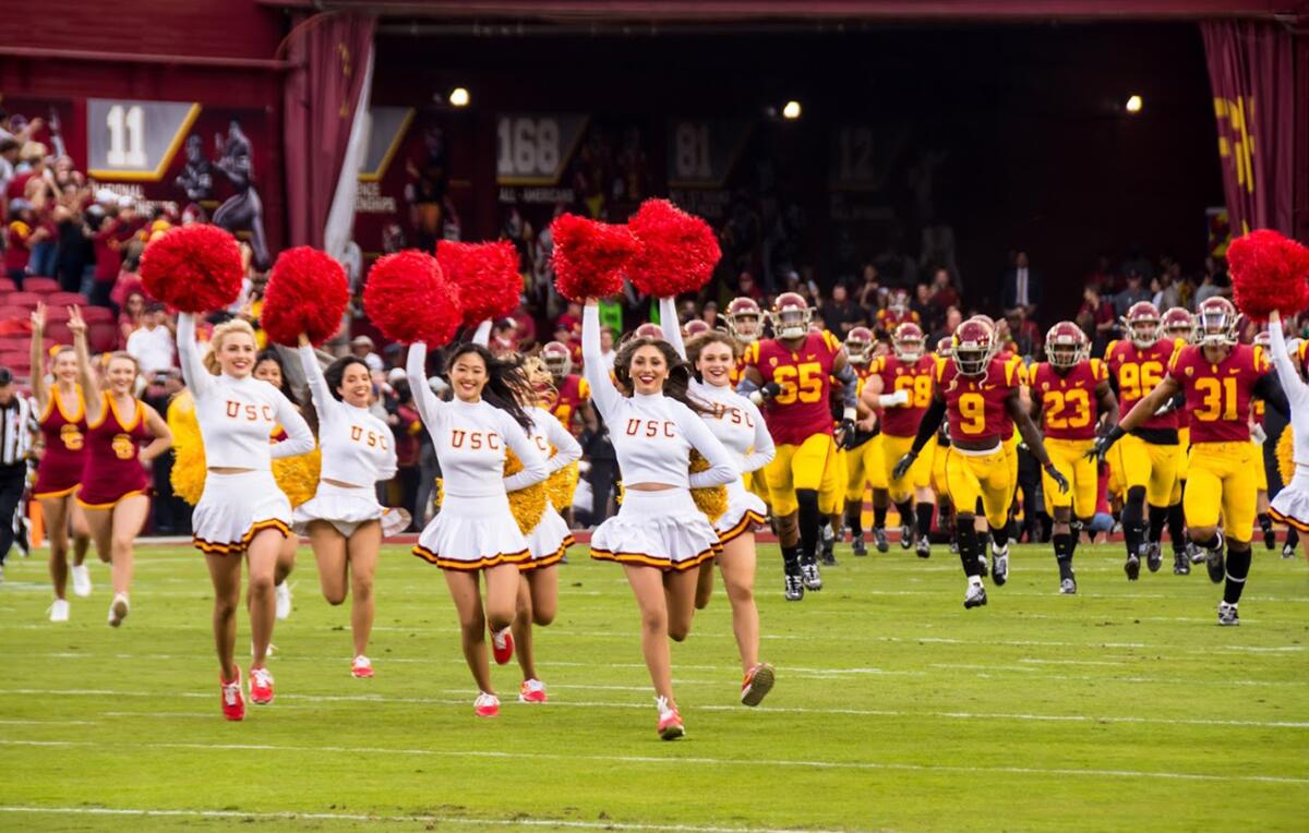 USC Song Girls, including Adrianna Robakowski, lead the Trojans onto the football field 