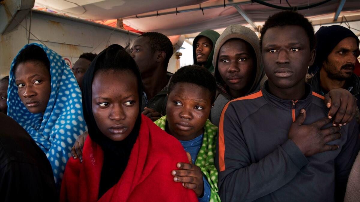 Migrants aboard the Golfo Azurro rescue vessel wait to be transferred to Italian authorities in Trapani harbor, on the Italian island of Sicily on Saturday.