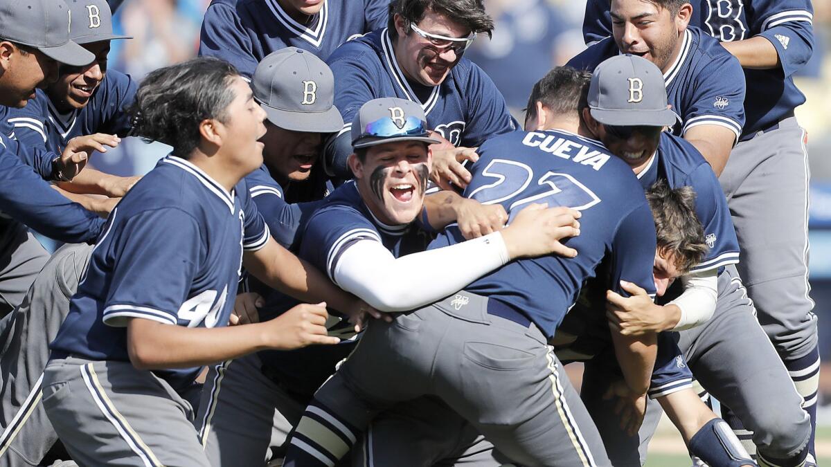 Relief pitcher Sebastian Cueva is mobbed by Birmingham teammates after a 9-6 victory over Palisades in the City Section Open Division championship game Saturday at Dodger Stadium.
