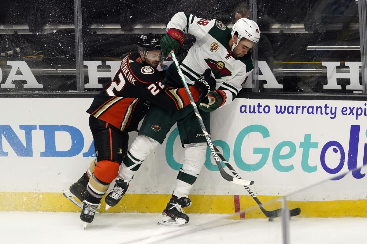 Ducks defenseman Kevin Shattenkirk pushes Minnesota Wild left wing Jordan Greenway against the boards.