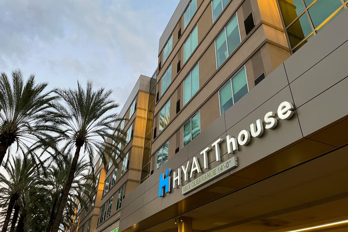 Palm trees next to a hotel exterior with a sign that says Hyatt House