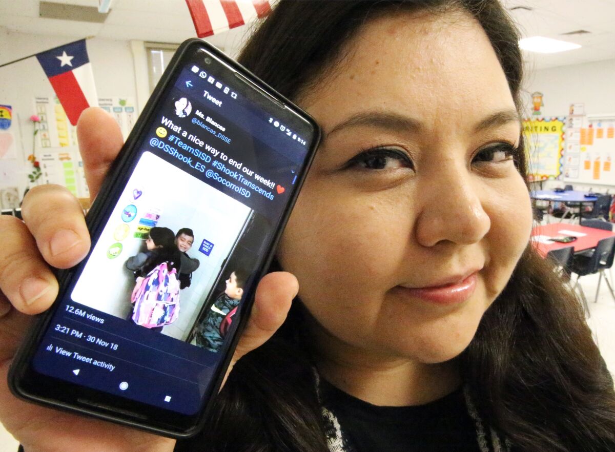 In this Dec. 18, 2018, photo, Zelene Blancas, a first-grade bilingual teacher at Dr. Sue Shook Elementary School in El Paso, Texas, shows the Twitter video she posted of her students hugging one another after class that went viral. Blancas died of COVID-19 in Dec. 2020. (Rudy Gutierrez/The El Paso Times via AP)