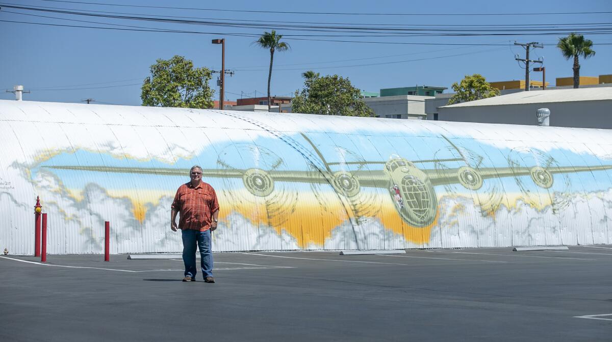Bruce Bear in front of a freshly painted mural of a B-24 Liberator on a Quonset hut built for the Santa Ana Air Base in WWII.