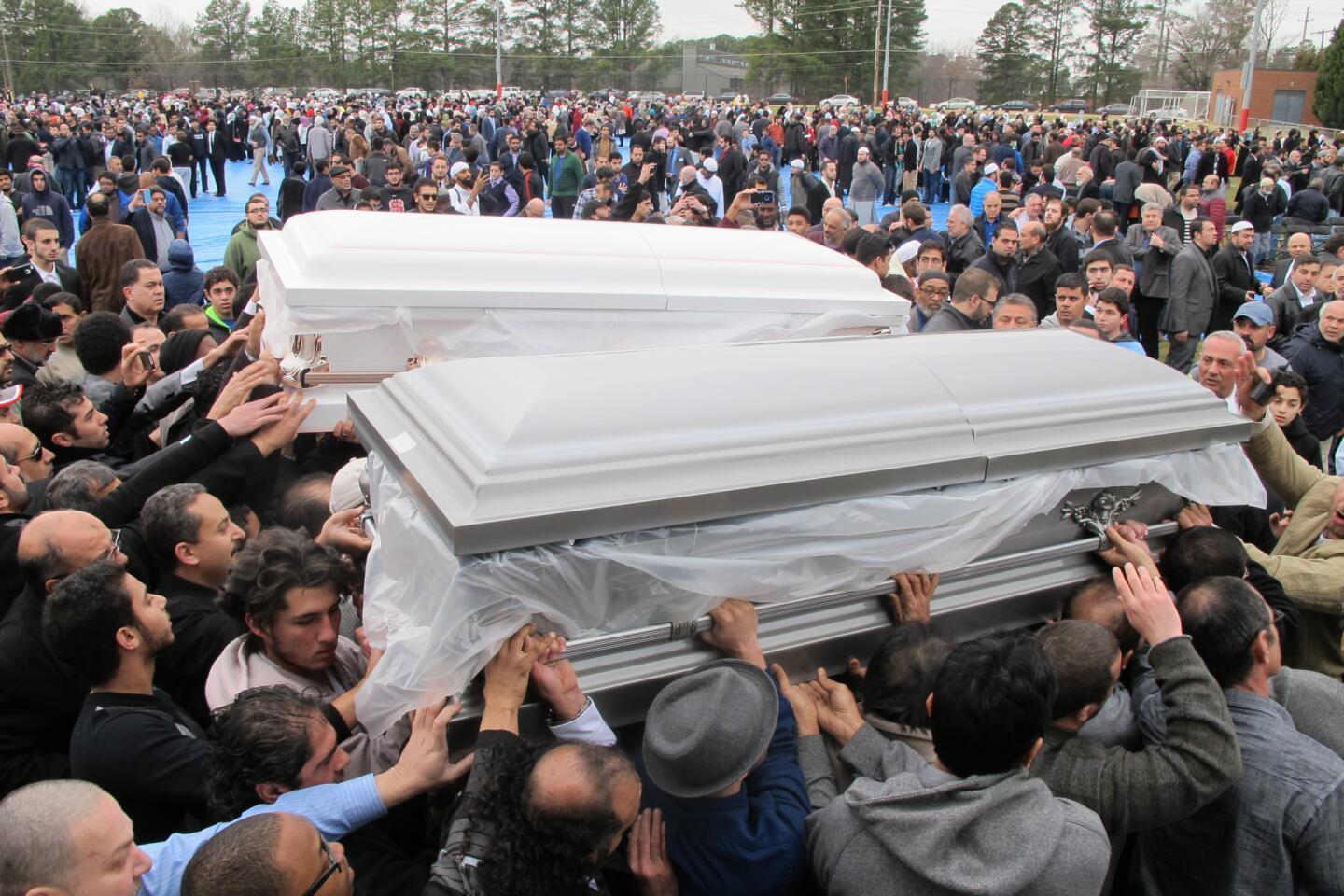 During a prayer service in Raleigh, N.C., mourners carry the caskets of two of three Muslim students who were shot to death.