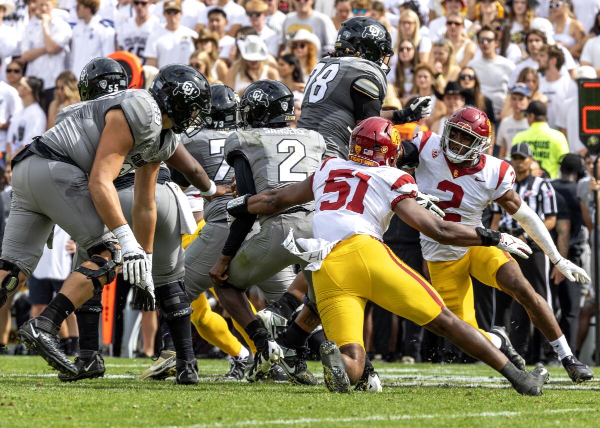 USC defensive end Solomon Byrd reaches in from behind to try and take down Colorado quarterback Shedeur Sanders 