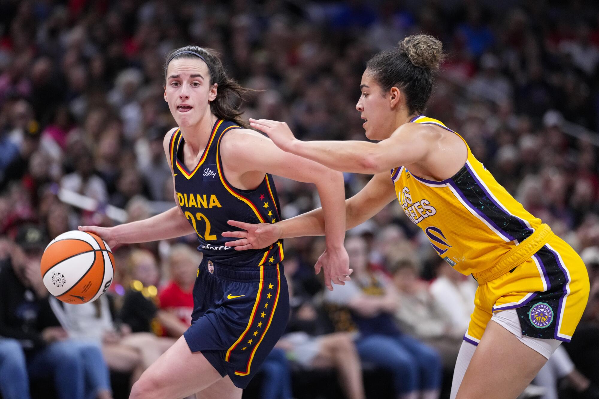 Indiana Fever guard Caitlin Clark, left, dribbles in front of Sparks guard Kia Nurse in Indianapolis on Sept. 4.