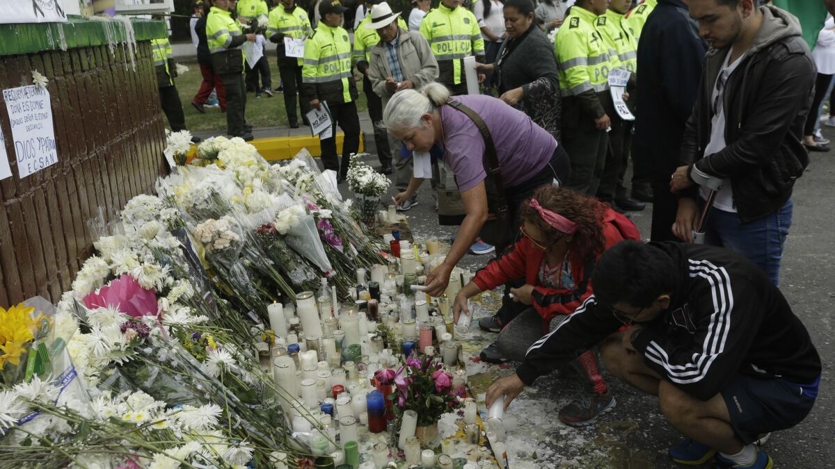 People light candles during a tribute to victims of a car bomb attack at the headquarters of the police academy General Santander in Bogota, Colombia, on Sunday.