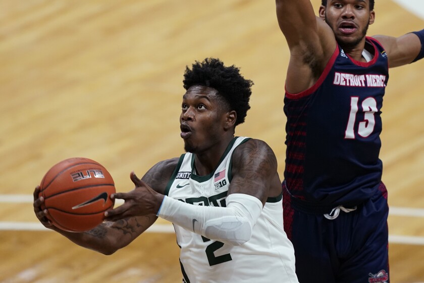 Michigan State guard Rocket Watts makes a layup as Detroit Mercy guard Matt Johnson (13) defends during the second half of an NCAA college basketball game, Friday, Dec. 4, 2020, in East Lansing, Mich. (AP Photo/Carlos Osorio)