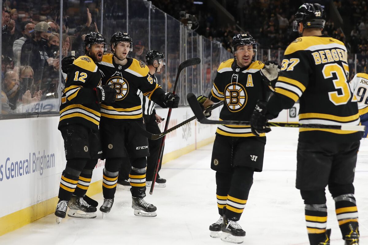Boston Bruins' Craig Smith (12) celebrates his goal with Urho Vaakanainen, Brad Marchand and Patrice Bergeron, right, during the first period of an NHL hockey game against the Nashville Predators Saturday, Jan. 15, 2022, in Boston. (AP Photo/Winslow Townson)