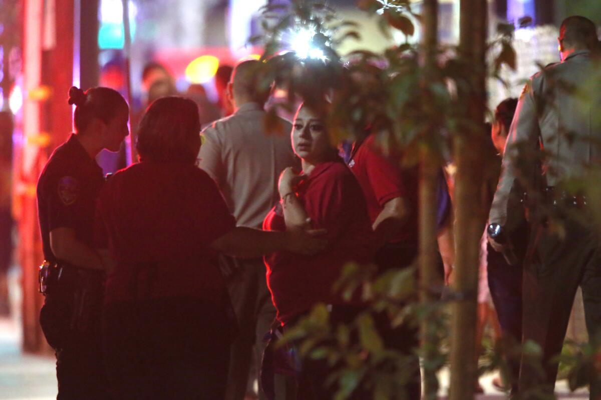 People who were evacuated wait outside the Downey restaurant that became the site of a standoff Thursday night.