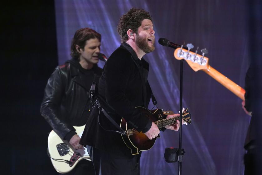 Tyler Burkum, left, and Josh Lovelace of NEEDTOBREATHE perform "I Wanna Remember" with Carrie Underwood at the CMT Music Awards on Wednesday, May 5, 2021, in Nashville, Tenn. The awards show airs on June 9 with both live and prerecorded segments. (AP Photo/Mark Humphrey)