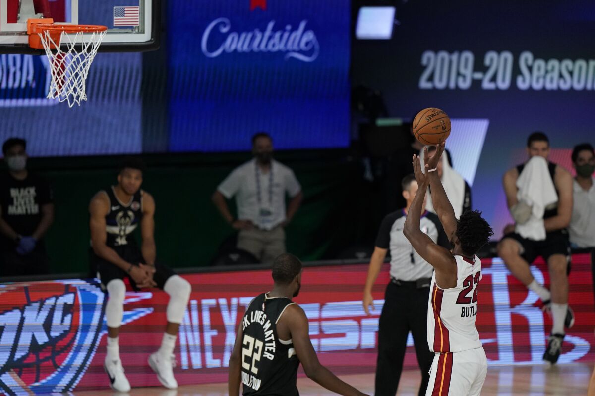 Miami Heat's Jimmy Butler (22) makes a free throw during the second half of an NBA conference semifinal playoff basketball game against the Milwaukee Bucks, Wednesday, Sept. 2, 2020, to give the Heat a 116-114 win over the Milwaukee Bucks in Lake Buena Vista, Fla. (AP Photo/Mark J. Terrill)