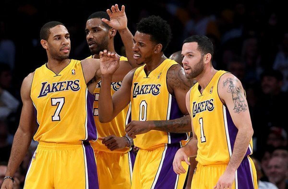 Lakers guard Nick Young (0) is congratulated by teammate Xavier Henry (7) after scoring and drawing a foul in the fourth quarter.