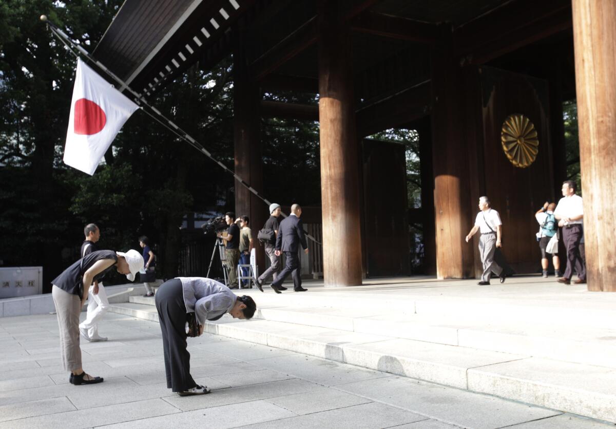 This Aug. 15 file photo shows worshipers bowing at Yasukuni Shrine in Tokyo. The Tokyo shrine, which includes the interred remains of war criminals, is one of a number of disputes disrupting relations between China and Japan.