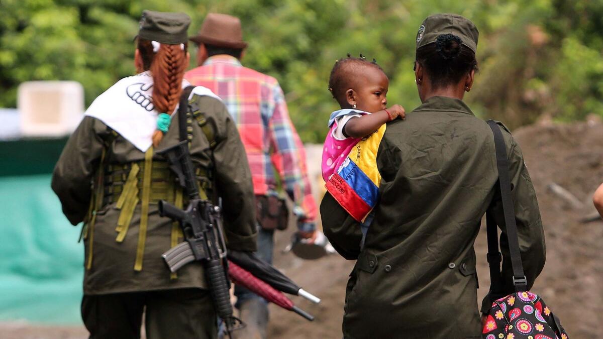 Guerrilla women from the Revolutionary Armed Forces of Colombia carry their babies in a camp site in Tumaco, Colombia.