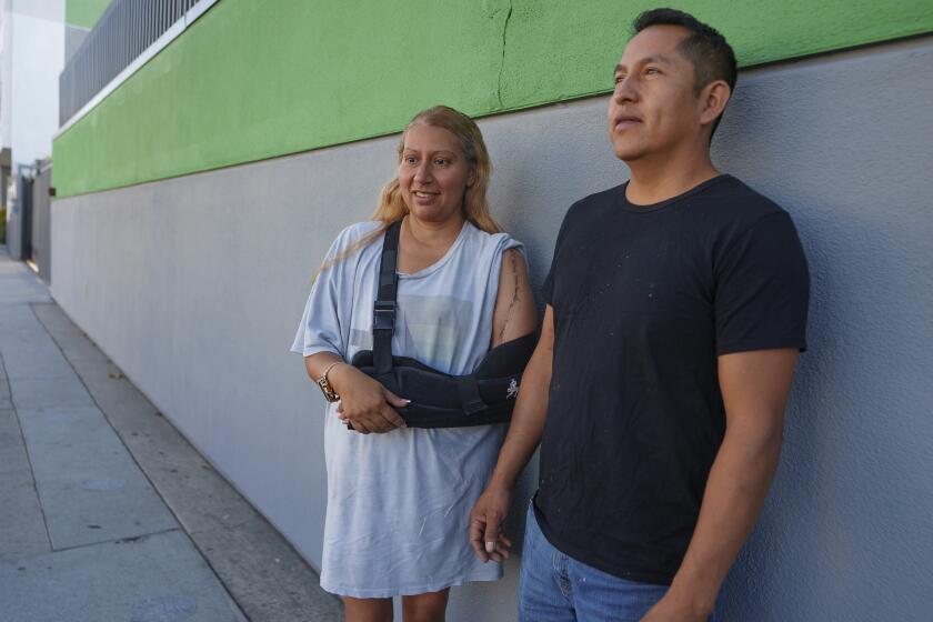 Roberto García y su esposa, María García, hacen una pausa para tomarse una foto tras dejar a sus dos hijos en su primer día de escuela en el Este de Los Ángeles el miércoles 14 de agosto de 2024. (AP Foto/Damian Dovarganes)