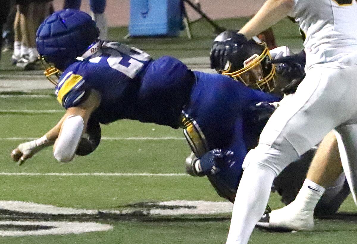 Fountain Valley's Sam Garza (26) dives for the first down against Marina in a nonleague game on Friday.