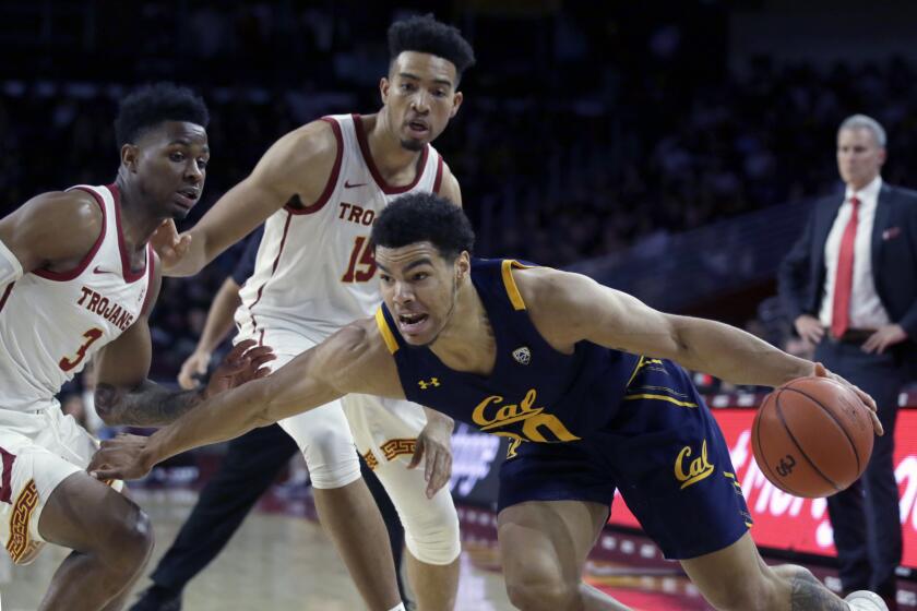 California guard Matt Bradley, right below, drives past Southern California guard Elijah Weaver, left, and forward Isaiah Mobley during the first half of an NCAA college basketball game in Los Angeles, Thursday, Jan. 16, 2020. (AP Photo/Alex Gallardo)