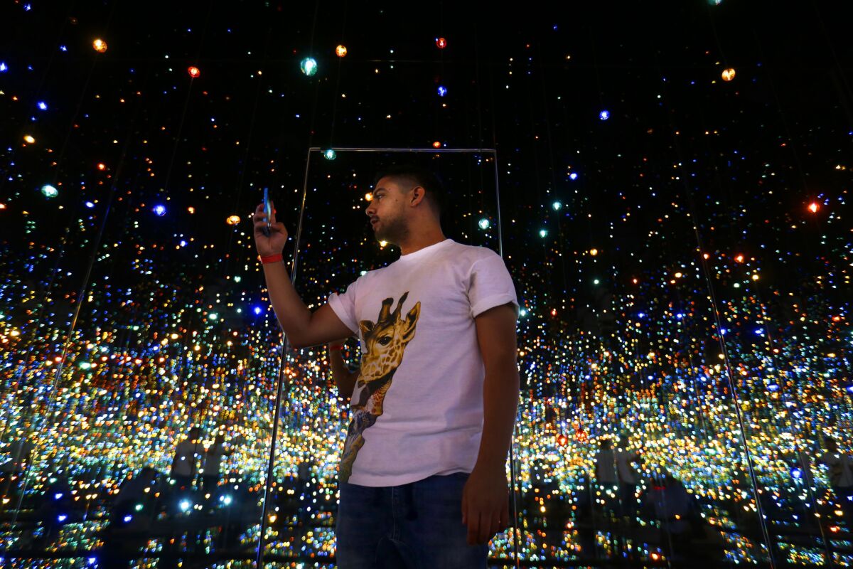 Scott Reyes, 26, of Los Angeles, stands inside Yayoi Kusama's 'Infinity Mirrored Room - The Souls of Millions of Light Years Away' on display at The Broad.